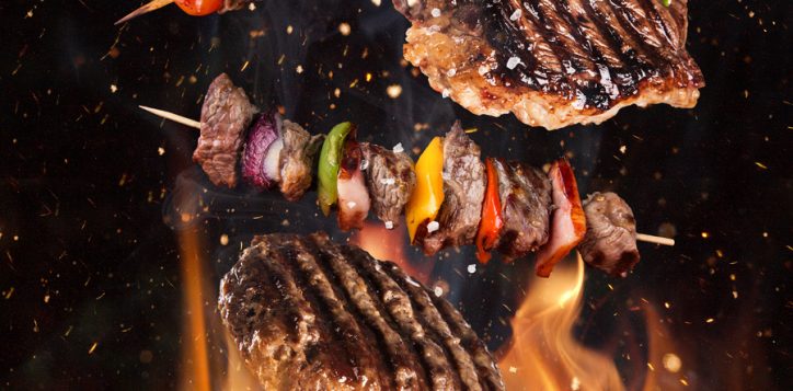 tasty-beef-steaks-and-skewers-flying-above-cast-iron-grate-with-fire-flames-2